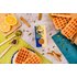 Das Produkt Zimt, Zucker & Co liegt mittig am Bild, es liegen Waffeln, Kardamom Kapseln und Zimtstangen daneben.